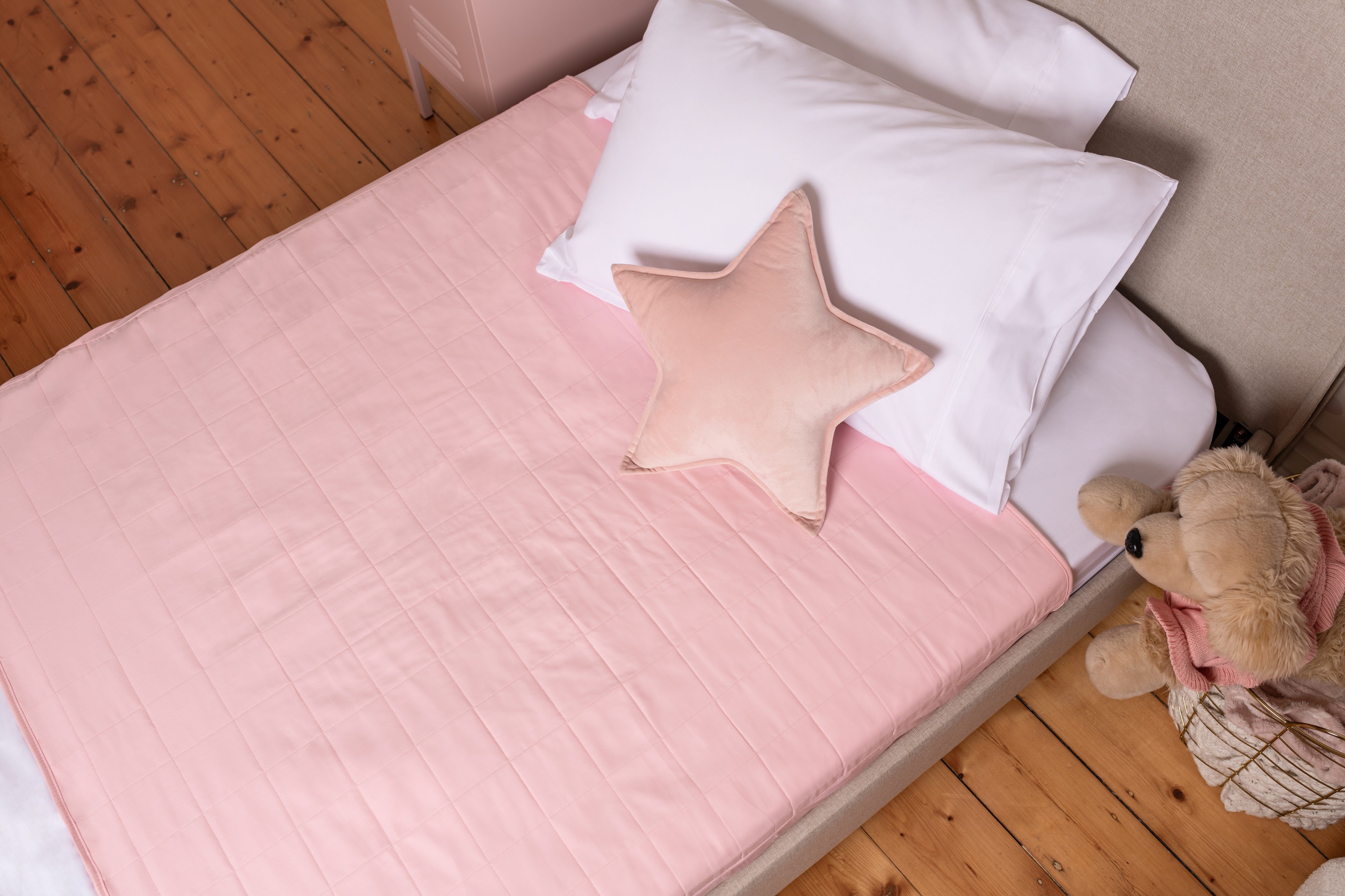 Dusty Pink waterproof bedwetting pad on bed, sustainable parenting solution